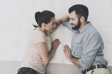 A couple chooses a mattress for themselves in the mattress store. They decided to try one and lie...