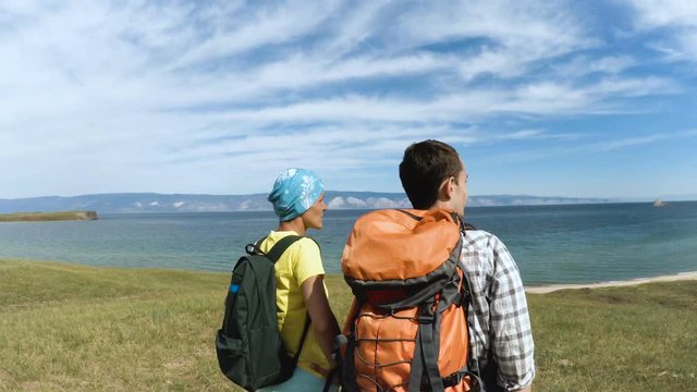 People hiking in lake Baikal. hikers pointing at blue lake. happy couple healthy lifestyle outdoors looking at Baikal view.
