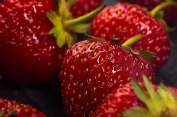 fresh ripe strawberries on black ceramic plate