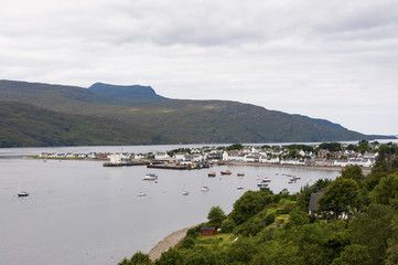 Fototapeta na wymiar Ullapool, Scotland - August 15, 2010: View of the fishing port and the village of Ullapool in the Highlands in Scotland, United Kingdom