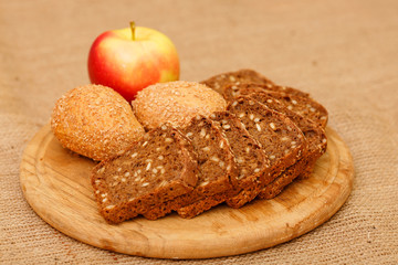 Biscuits baked from flour and bran. Cut pieces of black crusty bread. Diet bread useful for a healthy diet. Different types of bread is piled on the table in the composition. White and brown bread.