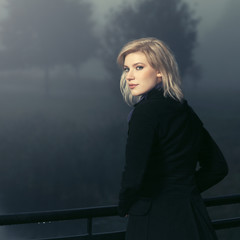 Young fashion woman by the lake in a night fog