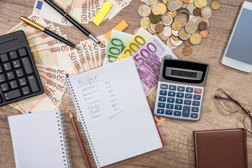 text budget on notepad, euro banknotes and coin, calculator, glasses, phone - obrazy, fototapety, plakaty