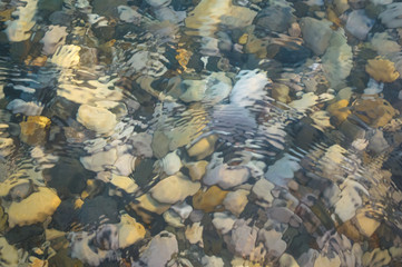 sea pebble beach with multicoloured stones, waves with foam