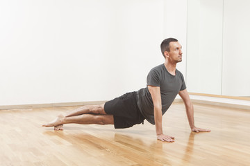 Naklejka premium Pilates instructor performing fitness exercise at the gym indoor