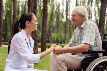 Obraz premium Doctor holding a smiling old man's hand