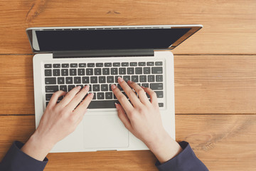 Fototapeta premium Female using laptop in coffee shop, close-up, top view