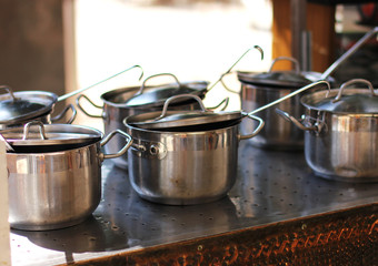 Six saucepans of stainless steel on the stove