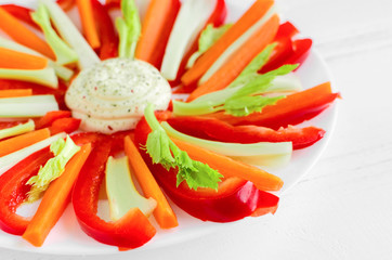 Colorful vegetable sticks in a plate with dip sauce