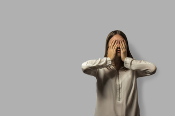 portrait of a young beautiful student girl with long hair. irritated and tired covered her face...