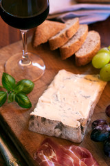 Piece of Spanish Blue cheese on an old wooden cutting board, selective focus. Close up