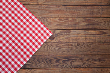 Obraz premium Old vintage wooden table with a red checkered tablecloth. Top view mockup.