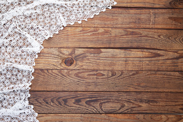 Old vintage wooden table with white tablecloth with lace. Top view mockup.