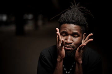 Portrait of afro american guy with hands near his face