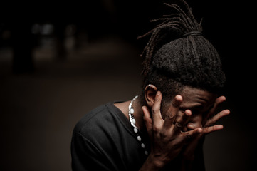 Portrait of the afro american guy with hands near his face