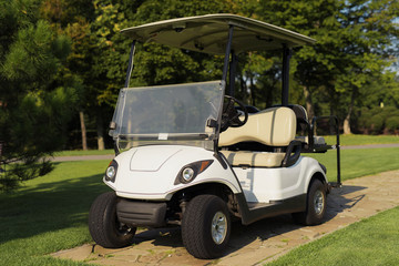 White golf cart on the stone path in the golf club