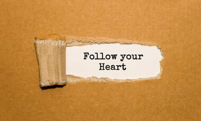 The text Follow your Heart appearing behind torn brown paper