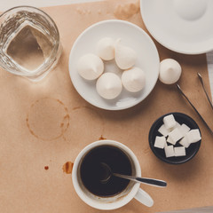 Black coffee cup and treats on craft paper background