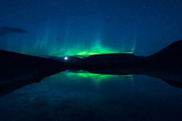 Obraz na płótnie Canvas The polar Northern lights aurora borealis in Norway Svalbard in Longyearbyen the mountains