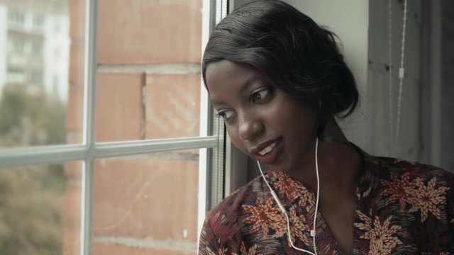 Young black woman listening music travelling looking outdoor the window, pensive - thoughtful, thinking future, music concept, african american student think about home
