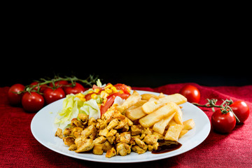 Chicken skewers with sauce and golden French fries potatoes