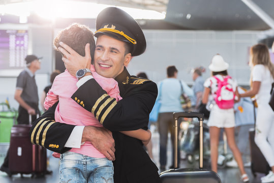 Hilarious aviator embracing little boy