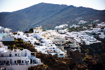 Naklejka premium Santorini Island, Greece, Europe. Traditional white Greek architecture over Caldera, a beautiful landscape with a blue sky and famous white houses and churches.