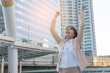 Winner woman celebrating success on city background.