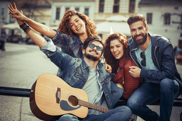 Group of young friends hangout on city square .