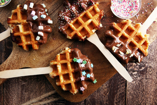Belgium waffles with chocolate sauce. popsicles with chocolate and wafer.