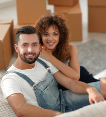Young couple sitting on the floor in a new apartment