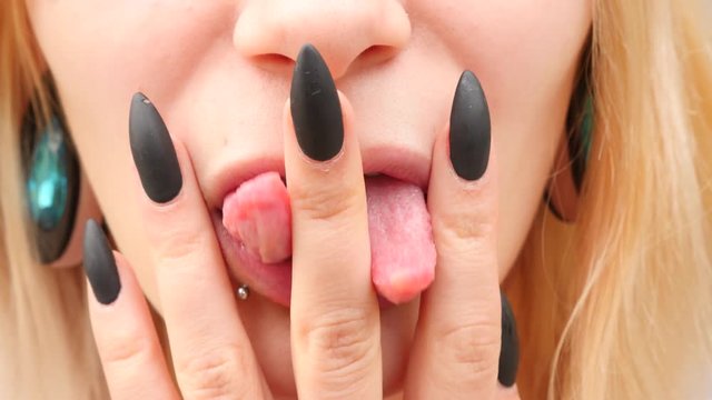 bodymification. a girl with a split tongue. licks a finger. 4k, slow-motion shooting, copying space