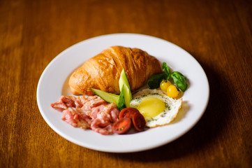 Fresh croissant with ham and salad