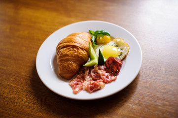 Fresh croissant with ham and salad