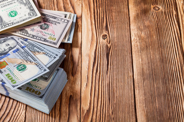 a purse with the American dollars is isolated on a wooden background