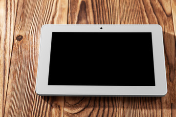 white tablet pc isolated on a wooden background