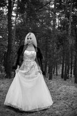 Fototapeta na wymiar A runaway bride in a wedding dress and a leather jacket in the forest. Difficulties at the wedding. Fashionable girl in grunge style