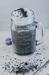 Goth Latte with charcoal and milk in a jar. Selective focus