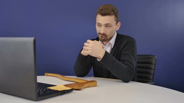 Angry businessman threatens partners with a wooden ax during video conference