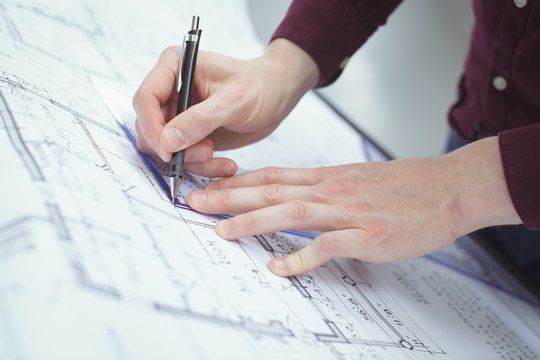 Mid section of architect working at drafting table