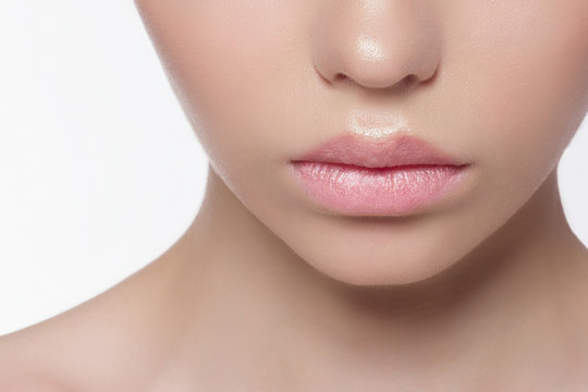 The macro photo of the closed female mouth with a natural shade of lips. Demonstration of care of skin of lips. Cosmetology, Spa, cosmetics, injections