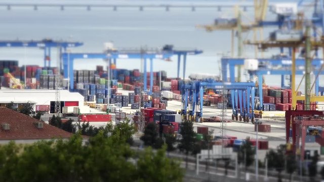 Huge Container Terminal In Lisbon, Tilt Shift Time Lapse. A container terminal is a facility where cargo containers are transshipped between different transport vehicles