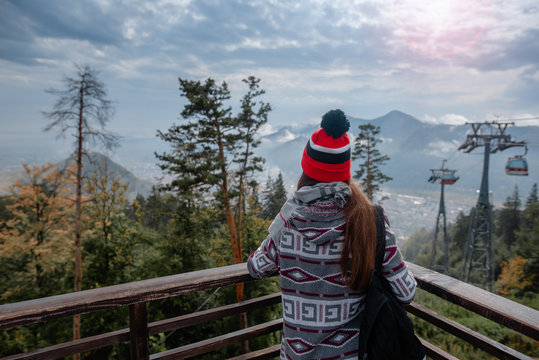 Hipster girl enjoying view of the mountains. Travel girl with backpack and orange hat. Romania, Piatra-Neamt.