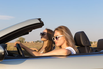 Two attractive young women in a cabriolet car