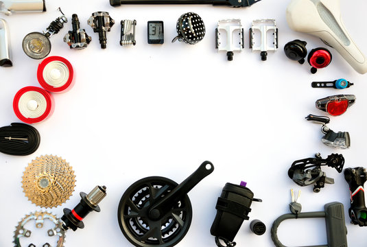 Części i akcesoria rowerowe ułożone na białym tle w formie ramki.