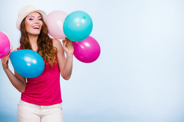 Naklejka premium Woman playing with many colorful balloons