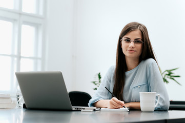 Secretary writing documents in her office.