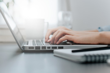 Woman working at home office hand on keyboard close up