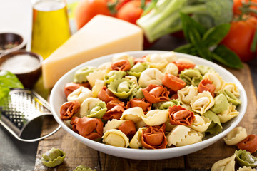 Red, white and green tortellini with vegetables and cheese