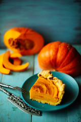 Traditional pumpkin pie preparation with filling, dough and ingredients on dark rustic background, top view, retro styled, frame